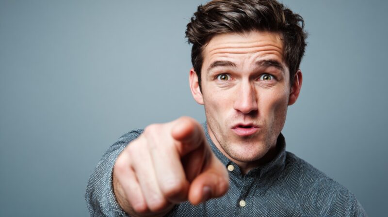 Muškarac pokazuje prstom ka posmatraču sa izražajnim licem
