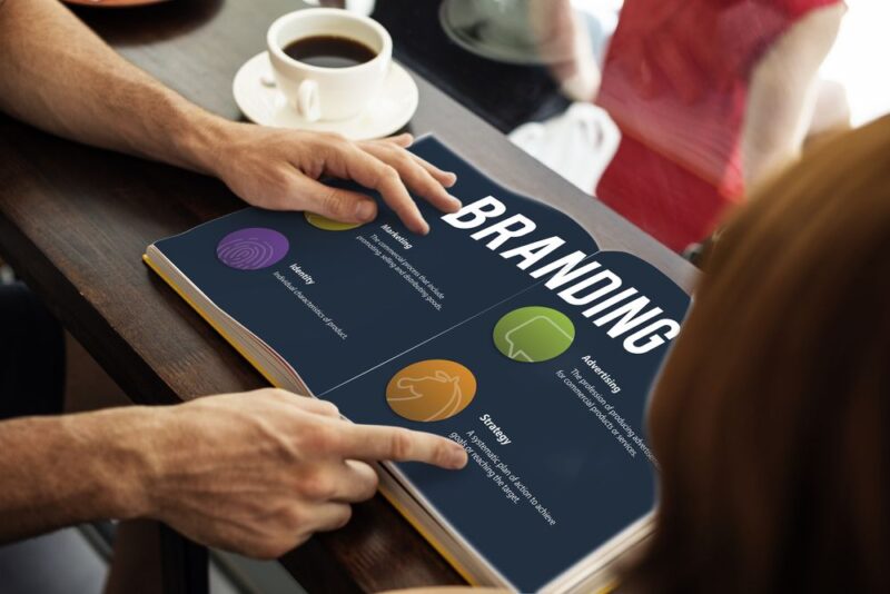 Poslovni tim pregleda brand book sa smernicama za brending i marketing